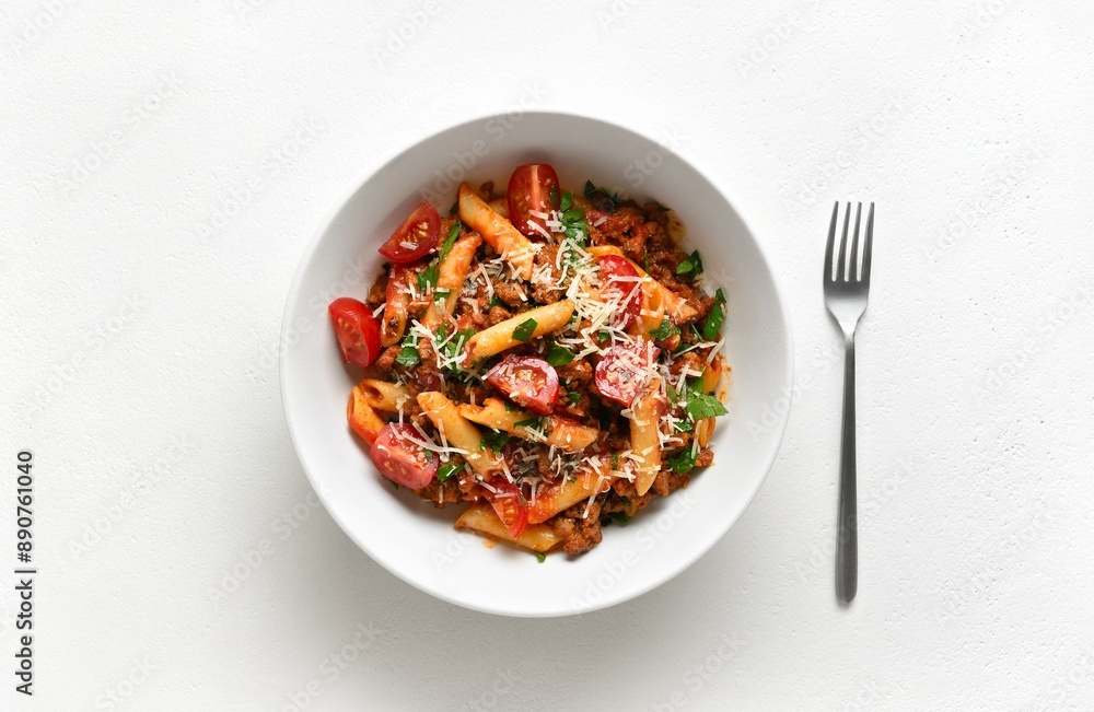 Bowl of bolognese penne pasta with minced meat, tomatoes and greens Bowl of bolognese penne pasta with minced meat, tomatoes and greens