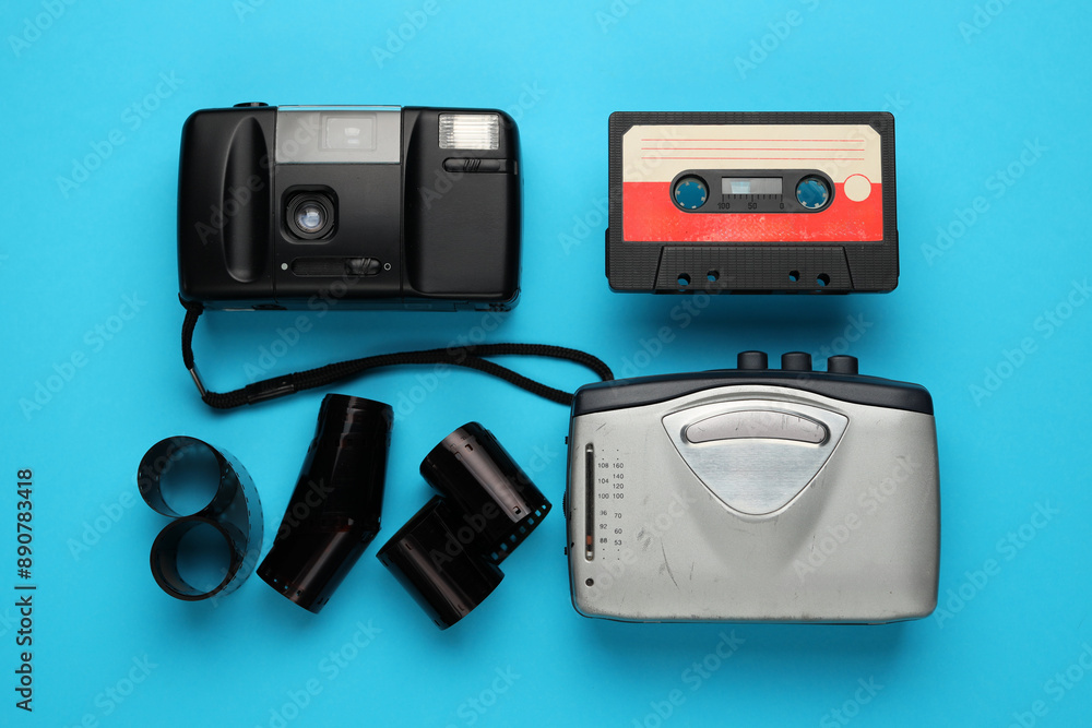 A camera, a cassette tape, and a roll of film are displayed on a blue background A camera, a cassette tape, and a roll of film are displayed on a blue background