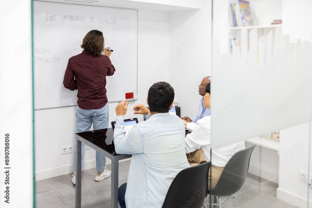 Team discussing and writing on whiteboard in English class Team discussing and writing on whiteboard in English class