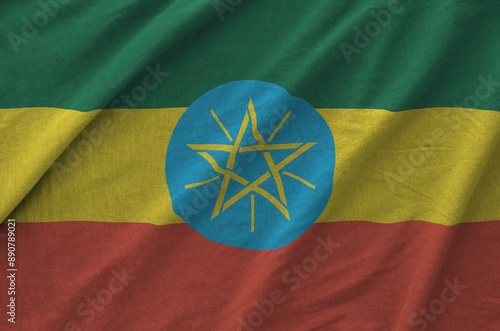 Ethiopia flag depicted on folded wavy fabric of old cloth close up photo