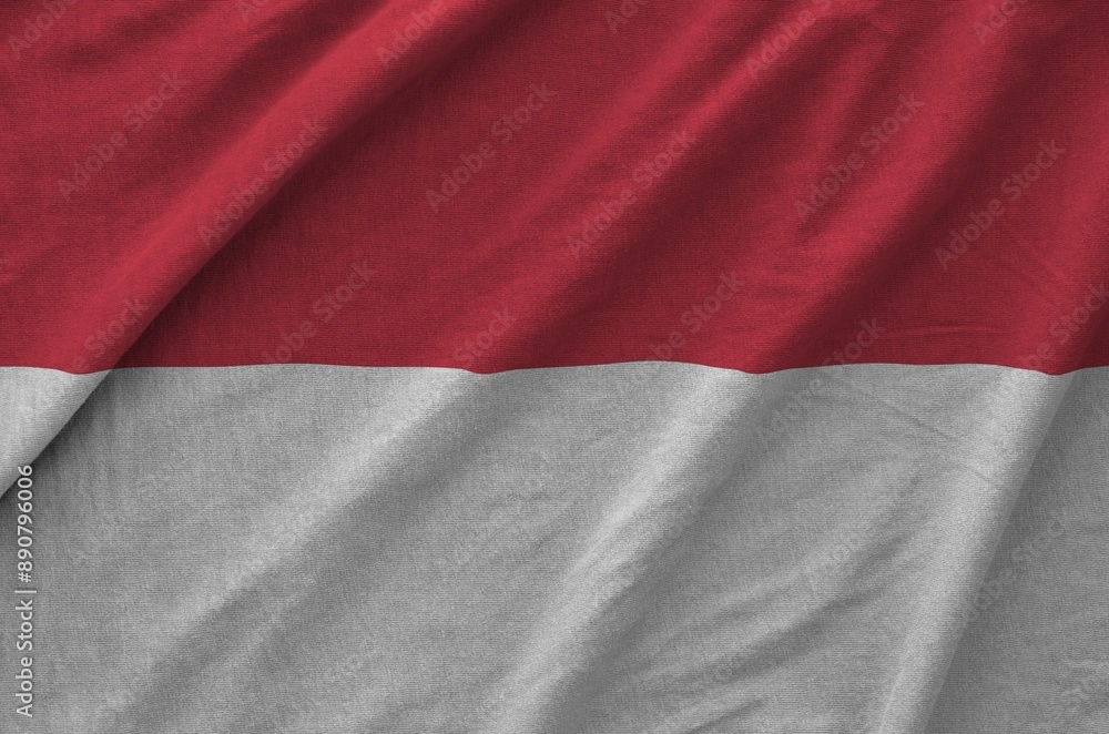 Monaco flag depicted on folded wavy fabric of old cloth close up Monaco flag depicted on folded wavy fabric of old cloth close up