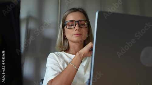 Woman in glasses working at home with computer 