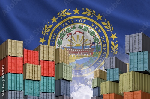 New Hampshire US state flag and big stack of shipping cargo containers in docks with sky background close up photo