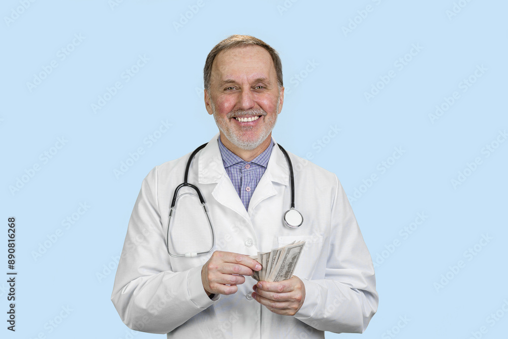 Portrait of a smiling male doctor is counting money. Isolated on blue. Portrait of a smiling male doctor is counting money. Isolated on blue.