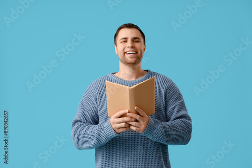 Happy young man reading boo...