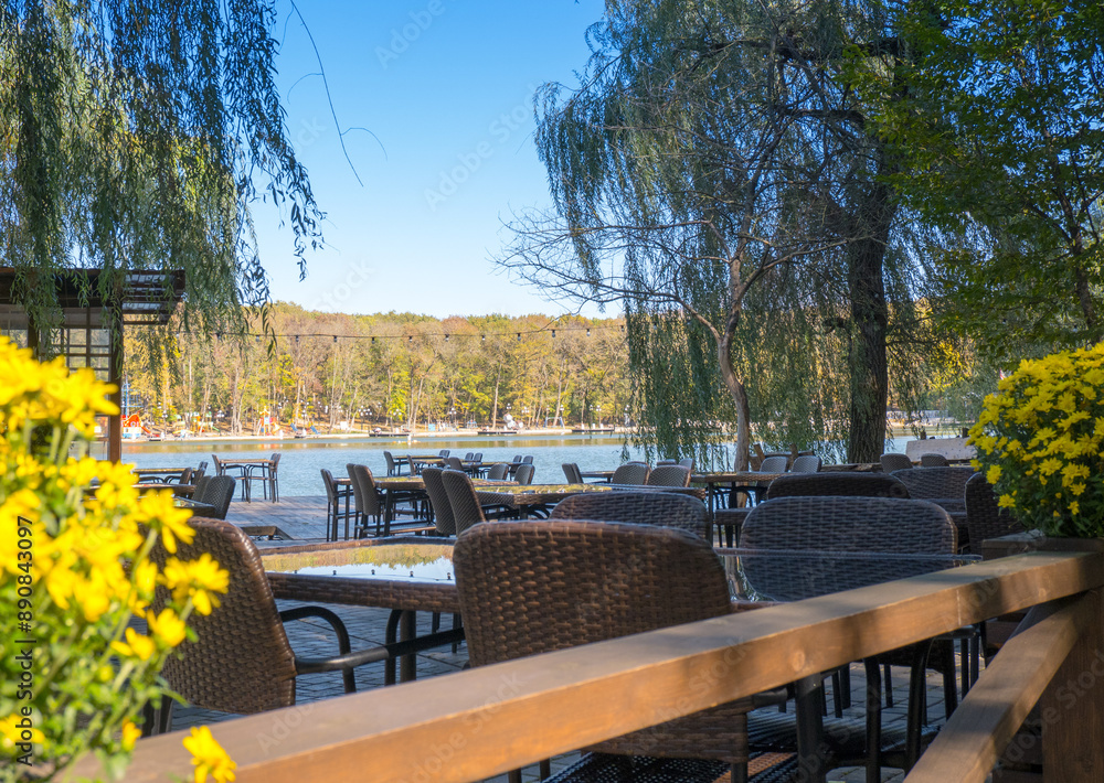 Recreation area in the city park. Outdoor tables and benches by the lake for relaxing and eating