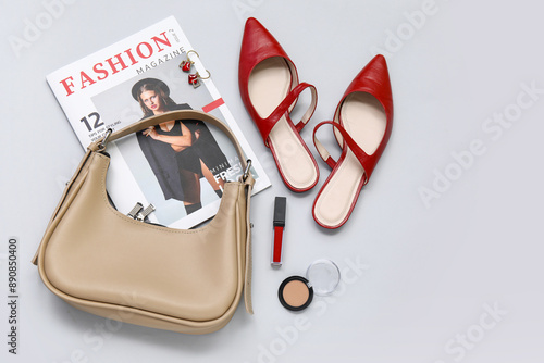 Red slingback flats, bag, magazine, lipstick, sculptor and earrings on white background photo