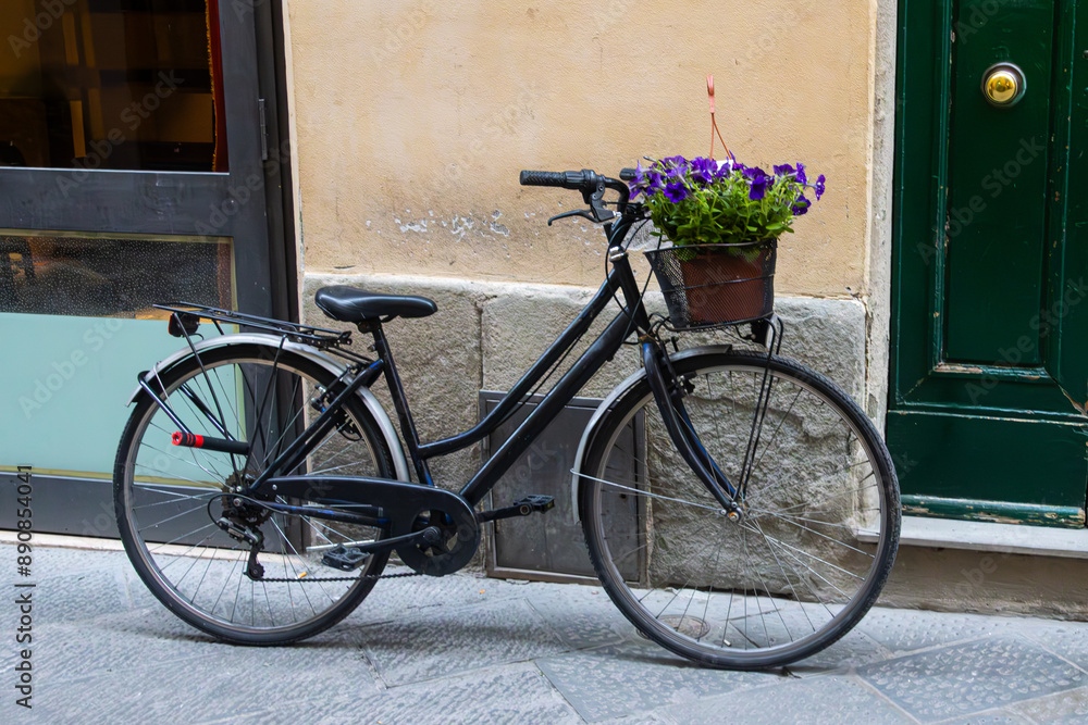 Bicycle with a basket of flowers parked on an alley Bicycle with a basket of flowers parked on an alley