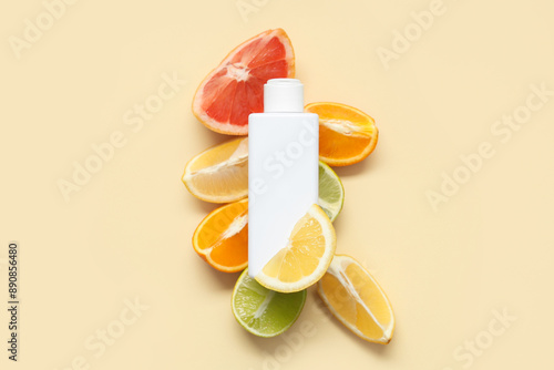Fototapeta Naklejka Na Ścianę i Meble -  Composition with pieces of citrus fruits and bottle of cosmetic product on yellow background