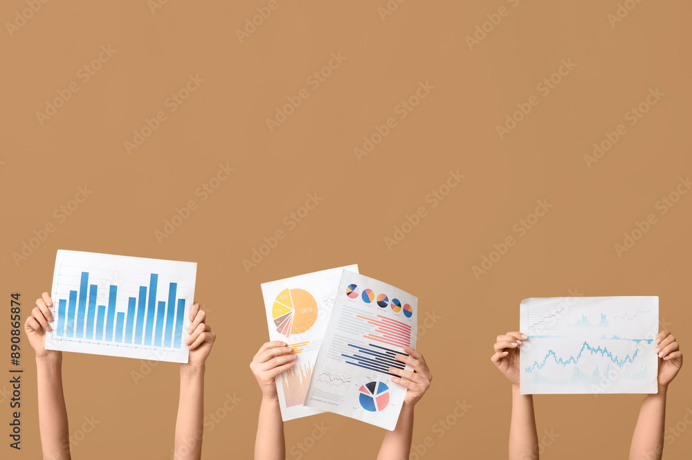 Female hands with different financial graphics on beige background Female hands with different financial graphics on beige background