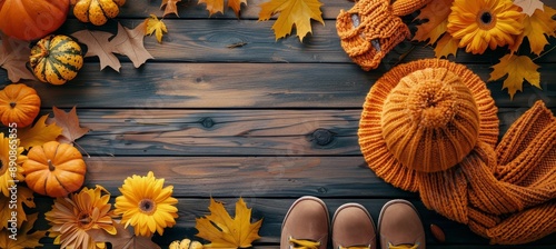 Orange Knitted Hat, Boots, and Scarf on Blue Wooden Background With Autumn Le...