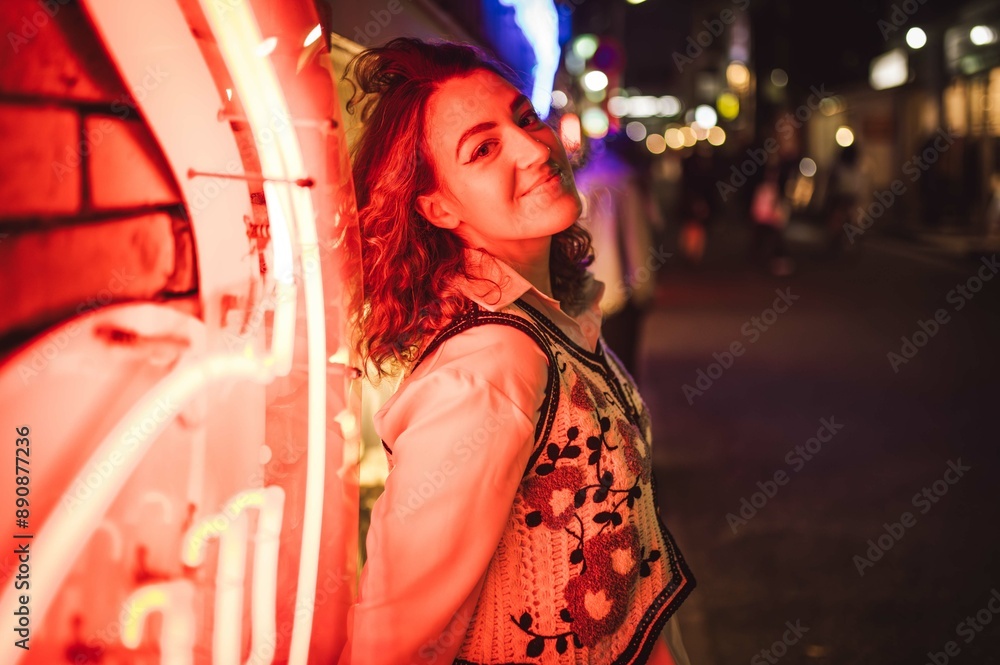 Fototapeta premium Woman Posing by Neon Lights in a Night Cityscape