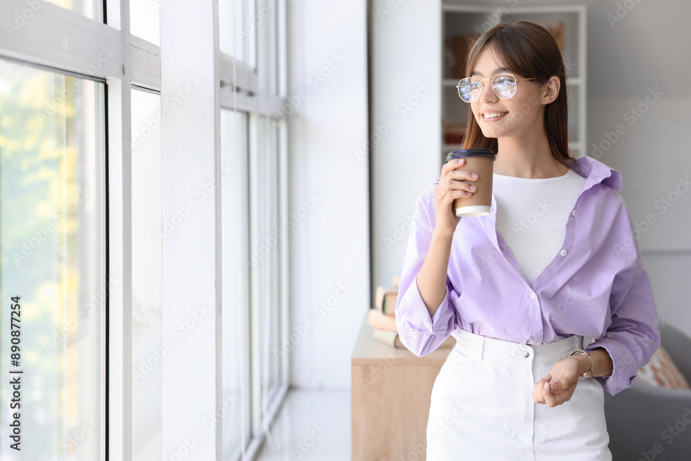 Young woman in eyeglasses with cup of coffee near window at home Young woman in eyeglasses with cup of coffee near window at home
