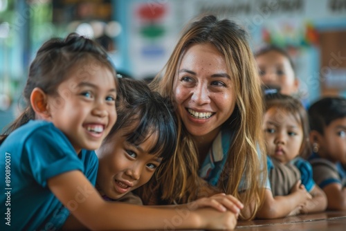Kind female teacher engaging with primary school students, making learning enjoyable and fun while stimulating curiosity and fostering a love of education in an interactive classroom setting.