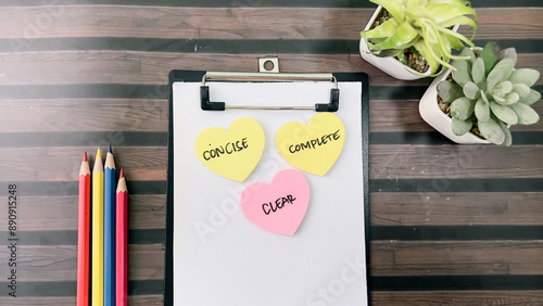 Concept of Concise, Clear, Complete write on sticky notes isolated on Wooden Table. photo