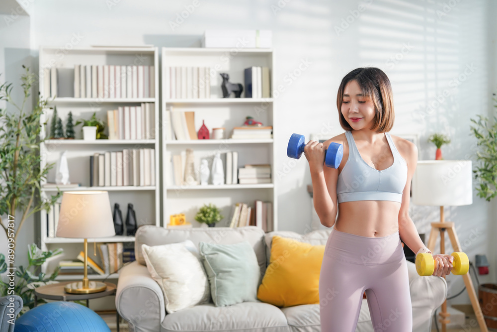 young attractive asian woman in sportswear doing exercise with dumbbell in the living room,concept of people lifestyle,health care,lose weight