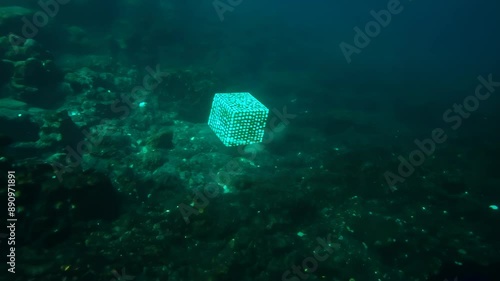 Wide shot: Glowing cubic creature hovers in murky underwater environment. Bioluminescent patterns cover its surface, emitting an ethereal aqua light.  photo