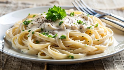 A detailed image of creamy spaghetti Alfredo, swirled with a creamy white sauce and topped with freshly ground black pepper and parsley, served on a white plate with a silver fork.