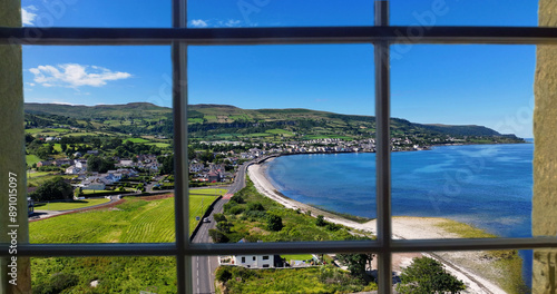 Looking through a window of the beautiful Glencloy on the Irish Sea Antrim Northern Ireland on a sunny day with a blue sky photo