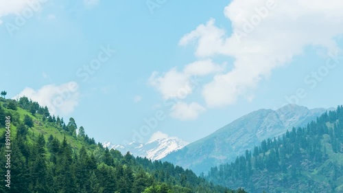 4K Zoom Out timelapse of beautiful summer mountains and clouds moving in sky at Burwa, Himachal Pradesh, India. green trees on mountains moving in wind. travel background. photo