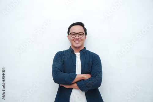 Handsome Asian man with crossed arm smiling to camera. Concept of student or business man. 