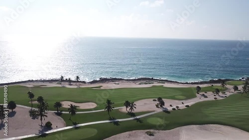 drone shoot of golf corse with point of view to the sea