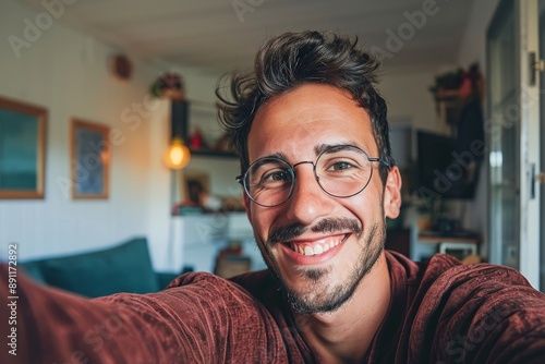 Happy young handsome millennial taking a selfie smiling at the camera in the living room at home, Generative AI © Art Gallery