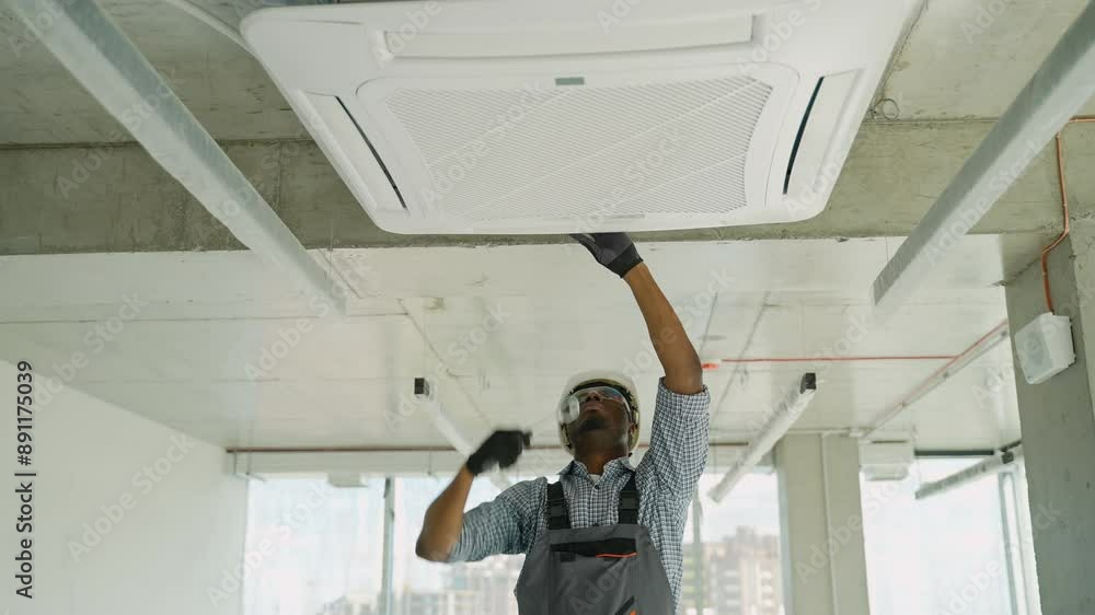 African american technician installing air conditioner indoor African american technician installing air conditioner indoor