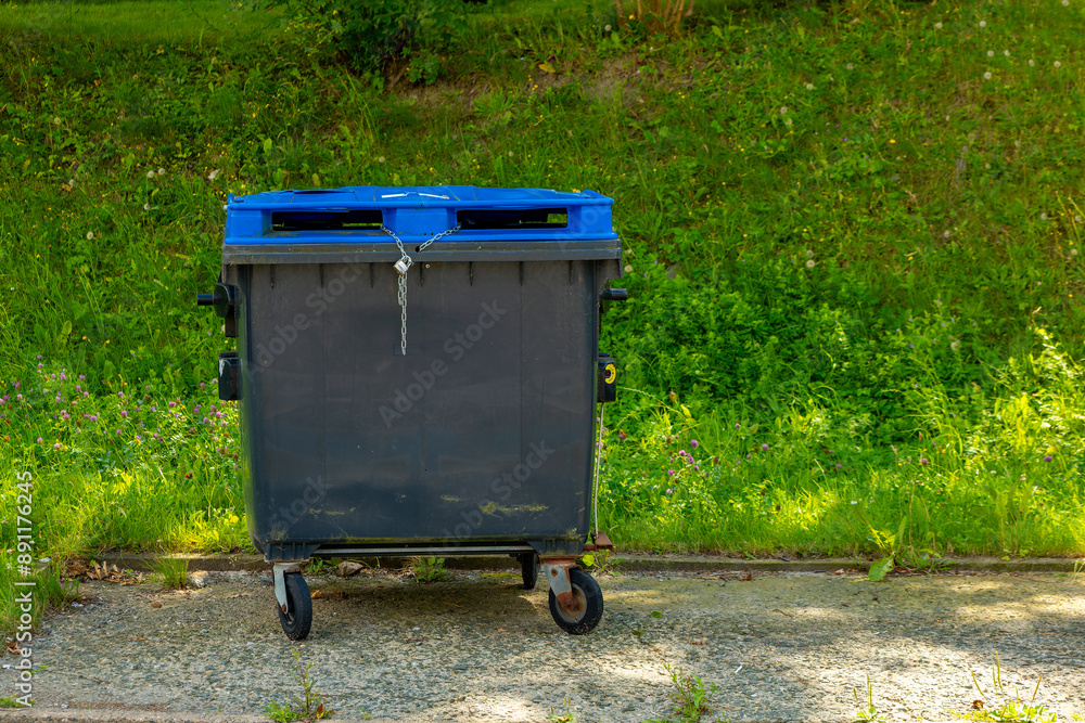 blue trash can is empty and has a chain on it blue trash can is empty and has a chain on it