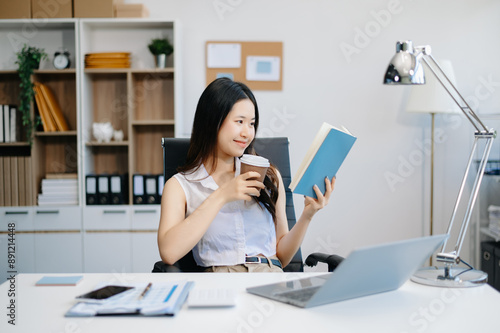 Asian businesswoman working in the office with working notepad, tablet and laptop