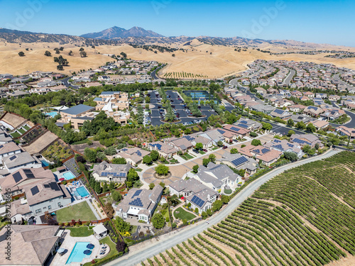 Aerial images over the Trilogy 55+ and older community in Brentwood, California with beautiful homes with solar, surrounded by hills with vineyards and mt.diablo