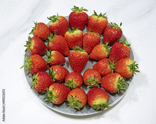 Close up and top angle view of strawberry with red fruits and stalk on white dish, South Korea
 photo