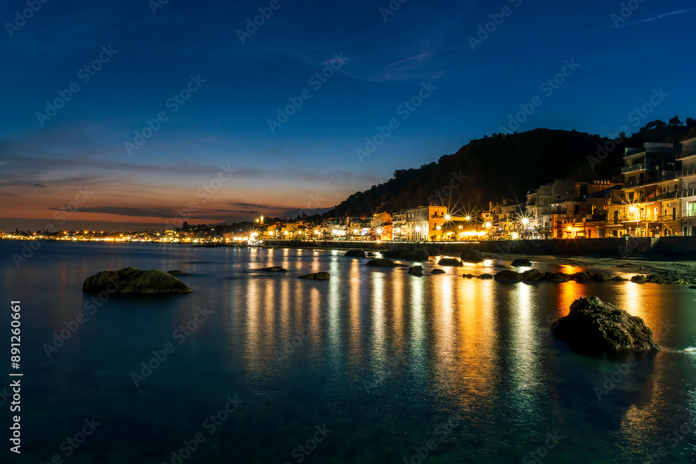 night town coast with flashlights from embarkment and reflection in sea gulf water with golden urbal lights and blue hour sky on background of landscape night town coast with flashlights from embarkment and reflection in sea gulf water with golden urbal lights and blue hour sky on background of landscape