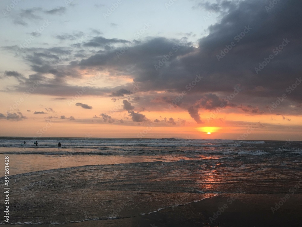 sunset at the beach with surfers sunset at the beach with surfers