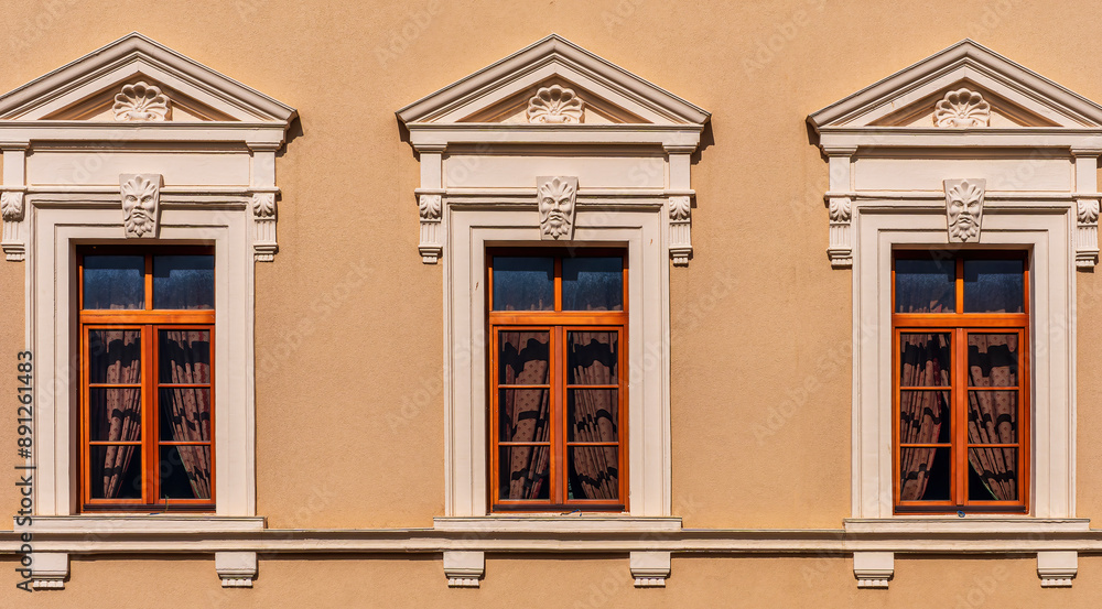 Fototapeta premium facade architecture wall with three beautiful vintage windows in old european style on warm yellow background