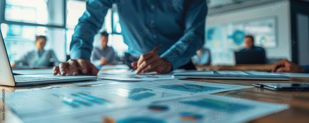 A professional analyzing charts and graphs during a business meeting, showcasing teamwork and strategic planning. A professional analyzing charts and graphs during a business meeting, showcasing teamwork and strategic planning.
