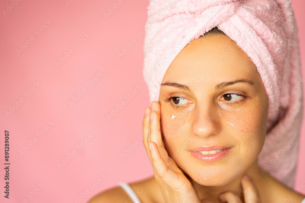 Young woman in the bathroom pink color with towel on her hair looking down usun eyepatches Young woman in the bathroom pink color with towel on her hair looking down usun eyepatches