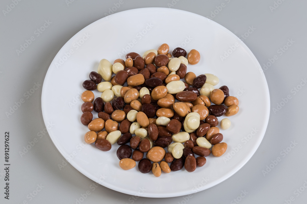 Raisins covered with dark, white and milk chocolate on dish Raisins covered with dark, white and milk chocolate on dish