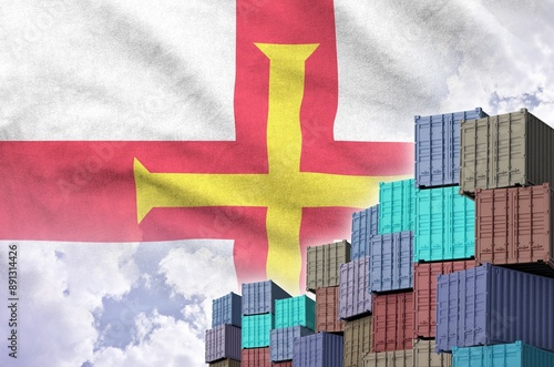 Guernsey flag and big stack of shipping cargo containers in docks with sky background close up photo