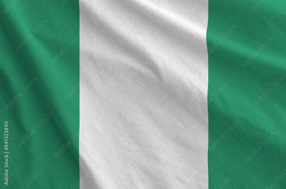 Nigeria flag depicted on folded wavy fabric of old cloth close up Nigeria flag depicted on folded wavy fabric of old cloth close up