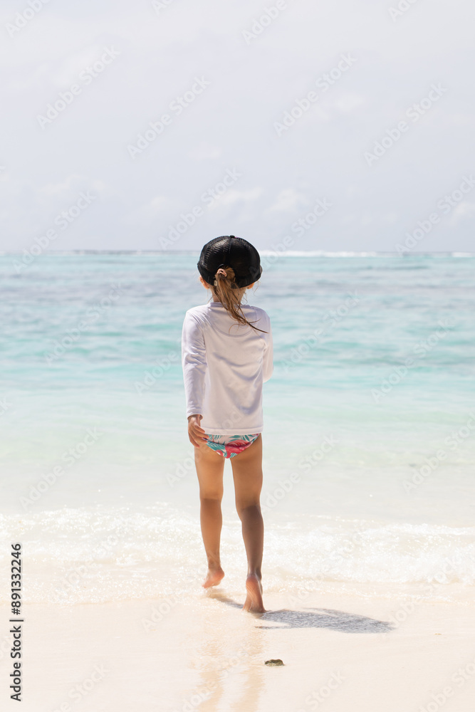 Young girl running joyfully on the beach, white sand, vitamin d, holidays with children, summer holidays Young girl running joyfully on the beach, white sand, vitamin d, holidays with children, summer holidays
