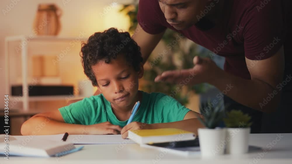 Irritated father talks down to son doing homework, too much pressure on a child Irritated father talks down to son doing homework, too much pressure on a child
