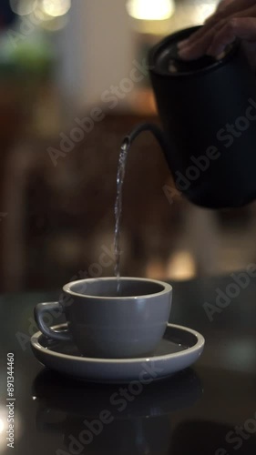 Person pouring hot water into a cup