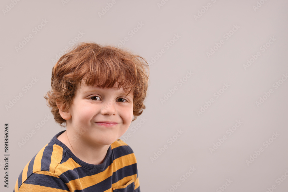 Portrait of cute little boy on grey background, space for text Portrait of cute little boy on grey background, space for text