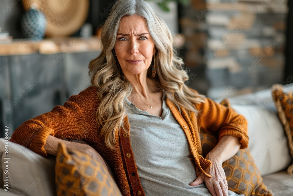 Middle-Aged Woman Experiencing Back Pain and Discomfort While Sitting on a Couch, Representing the Struggle of Chronic Pain and Its Impact on Everyday Life Middle-Aged Woman Experiencing Back Pain and Discomfort While Sitting on a Couch, Representing the Struggle of Chronic Pain and Its Impact on Everyday Life