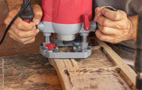 wood carver working on a piece of wood using a router  photo