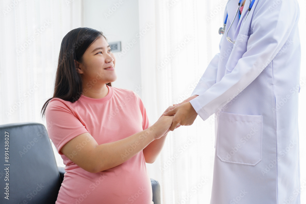A pregnant woman sits on the sofa in the clinic. The doctor examines her abdomen and reviews the ultrasound results. Offering encouragement, the doctor holds her hand, providing support and care. A pregnant woman sits on the sofa in the clinic. The doctor examines her abdomen and reviews the ultrasound results. Offering encouragement, the doctor holds her hand, providing support and care.