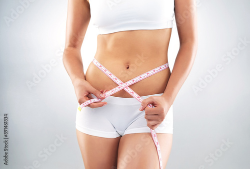 Woman, tape measure and studio for nutrition, weight loss and detox on white background. Stomach, exercise and healthy diet for female person, wellness and waist for slimming and progress results