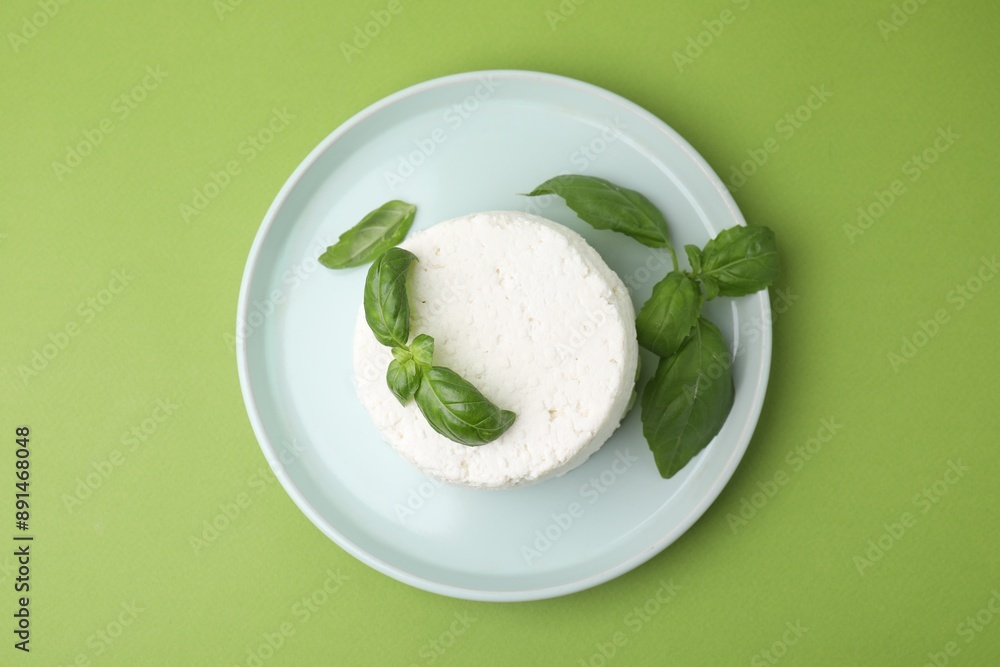 Fresh ricotta (cream cheese) and basil on green table, top view Fresh ricotta (cream cheese) and basil on green table, top view