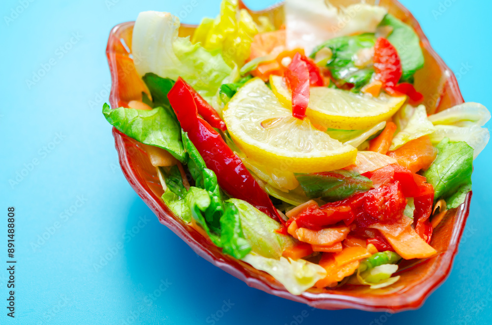 A bowl of salad with a lemon slice on top A bowl of salad with a lemon slice on top